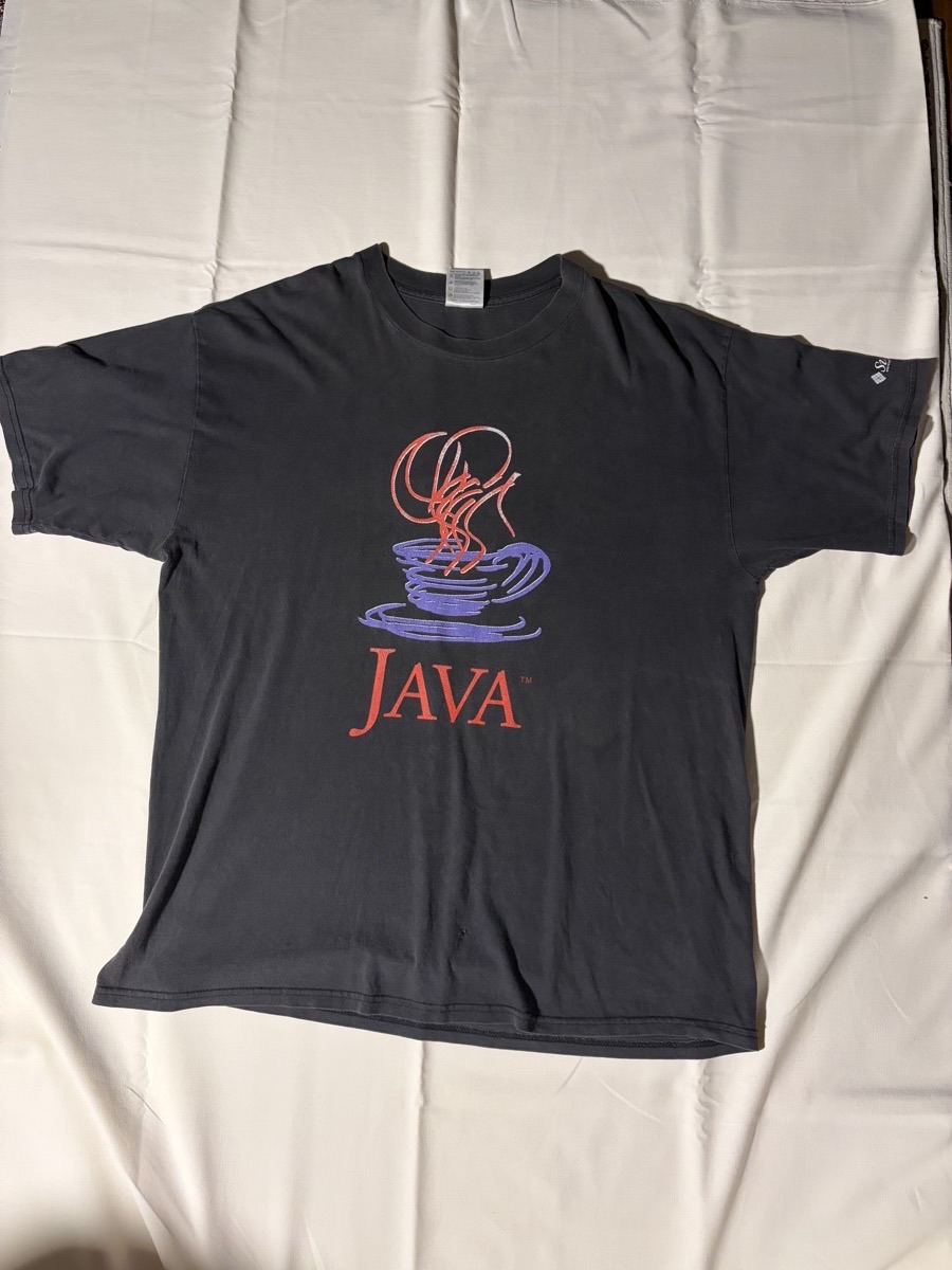 JAVA / Sun Microsystems のヴィンテージTシャツ。褪色した黒地に、赤と紫で湯気の立つコーヒーカップのJavaロゴがプリントされている。