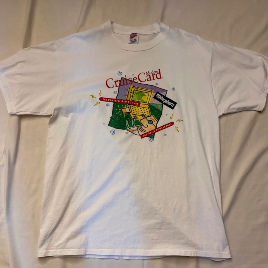 Megahertz CruiseCard Modem のヴィンテージTシャツ。白地に、ノートPC（Apple PowerBook）とPCカードを描いたポップなグラフィックと『CruiseCard Modem』『Megahertz』のロゴがプリントされている。